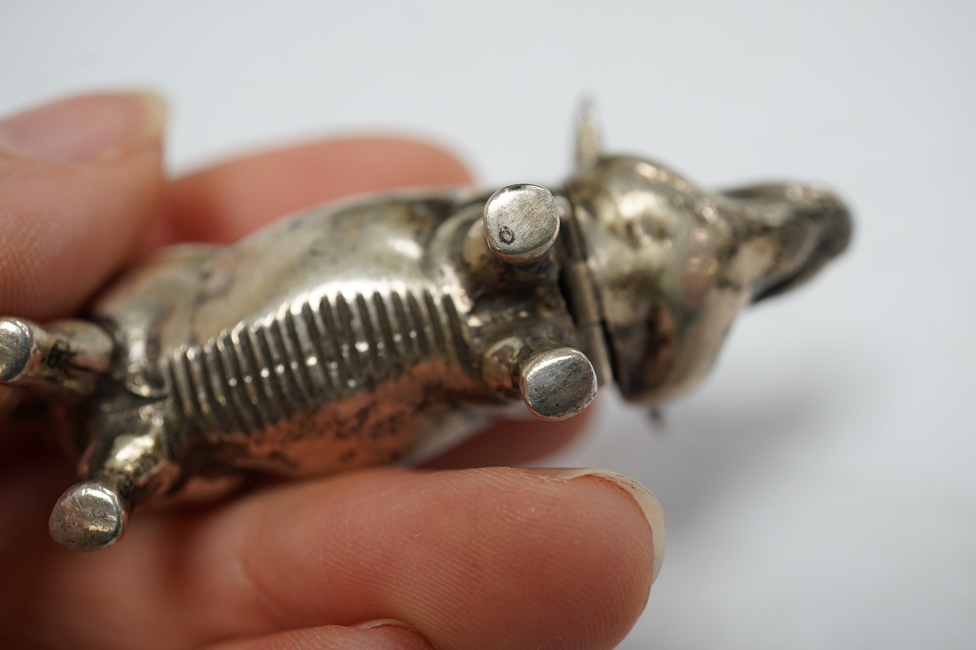 A modern silver novelty vesta case modelled as a pig, by David A. Bowles, London, 1902, 62mm, together with a novelty sterling whistle modelled as a dog's head. Condition - fair to good